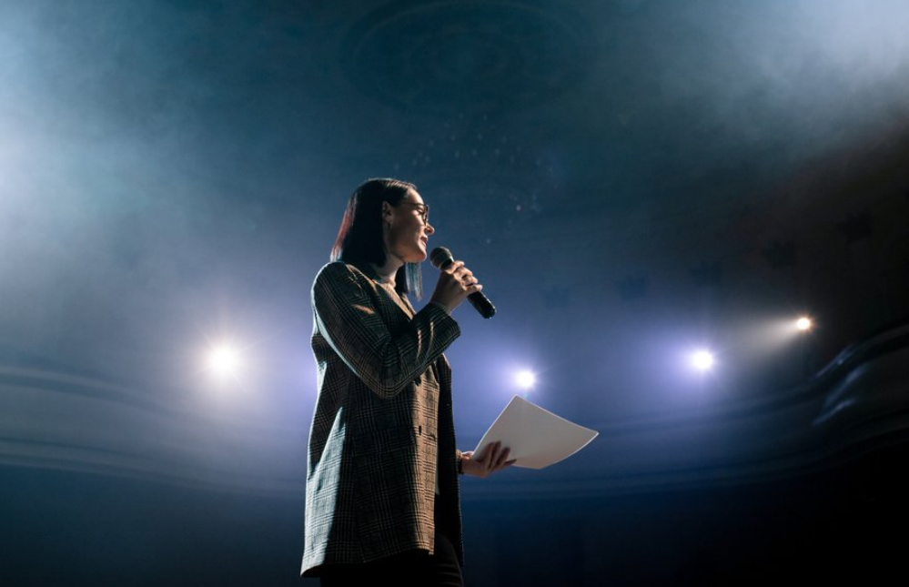 Image of a young professional speaking on stage.